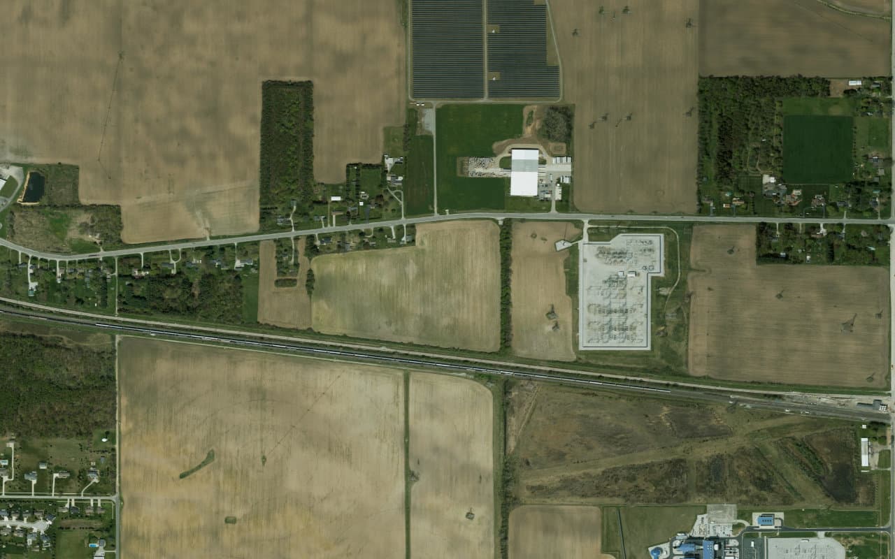 Satellite aerial of AWS Project Rainier infrastructure near New Carlisle, Indiana — substation, solar, and rail corridor